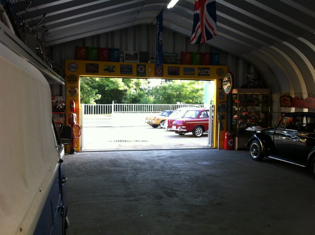 Una vista interior de un garaje con coches antiguos y otros antigüedades.