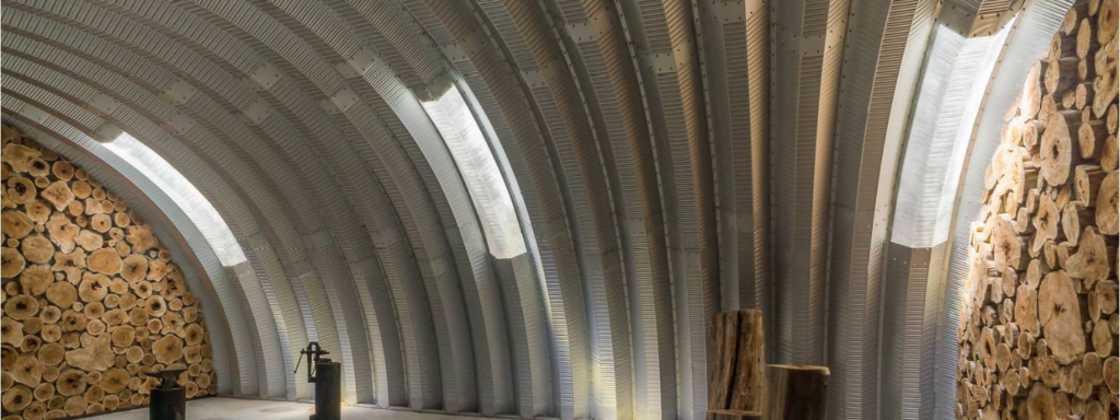 la vista dentro de una estructura metálica mirando los tragaluces, arcos de acero y paredes finales de madera